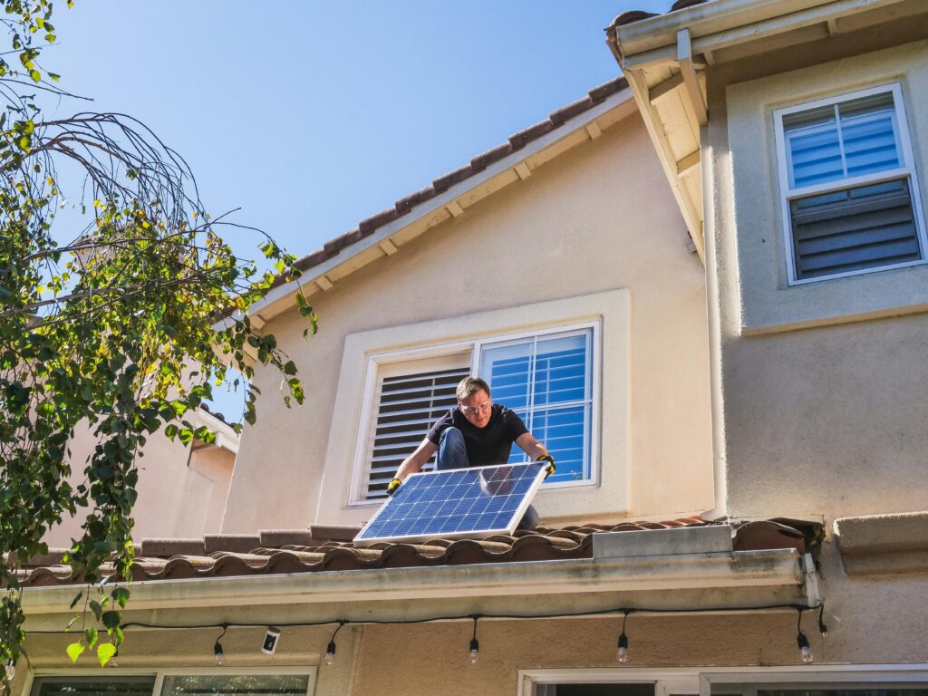 Close up of electrician installing solar panels on the roof of a house