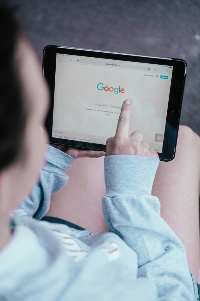 Over the shoulder shot of a girl browsing google on her ipad.